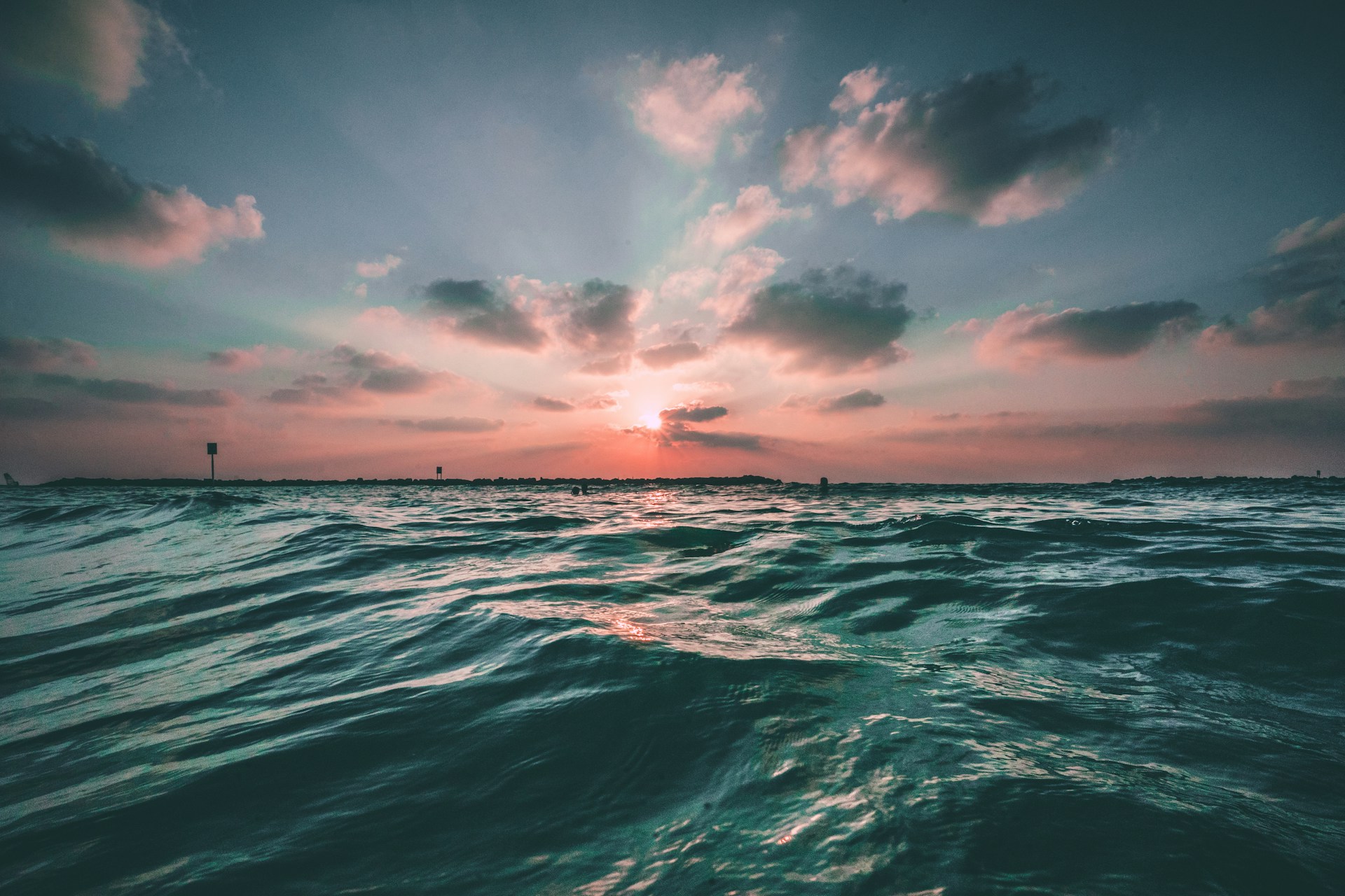 A sunset over the ocean with waves crashing